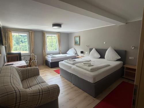 a bedroom with a large bed and a couch and a chair at Gasthaus Hotel Löffelschmiede in Hinterzarten