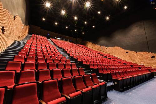 an auditorium with red seats in a theatre at Hotel Nanta Jeju in Jeju