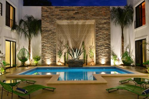 a swimming pool in a house with chairs and a table at Elements Tulum Boutique Hotel in Tulum