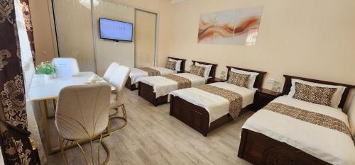 a group of four beds in a room at Registan Stay in Samarkand