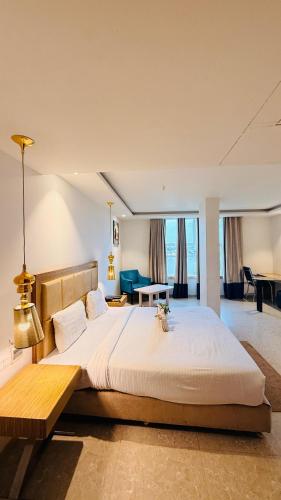 a bedroom with a large bed and a living room at HOTEL AMORA - Rajnandgaon in Rāj Nāndgaon