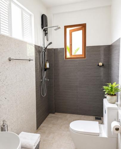 a bathroom with a shower and a toilet and a sink at Bliss Stay in Katugastota
