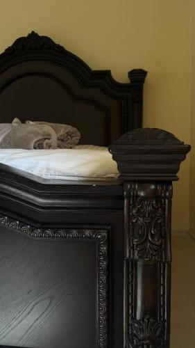 a bed with a wooden frame and white sheets at R Limoli Vintage in Trávnica
