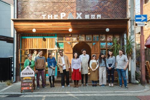 a group of people standing in front of a building at The Pax Hostel in Osaka