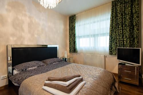 a bedroom with a bed with towels on it at Sia Mountain Apartment in Predeal