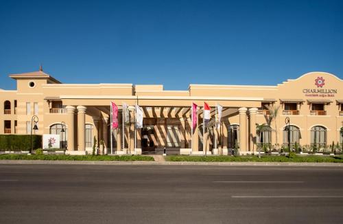 a building with flags in front of a street at Charmillion Gardens Aquapark in Sharm El Sheikh