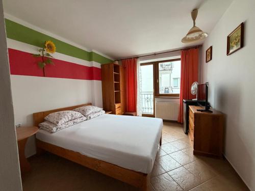 a bedroom with a bed with a red white and green wall at Kapitan Hook in Mielno