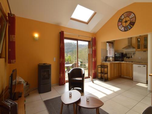 a kitchen and living room with a table and a clock at Cottage in Aywaille with Garden in Aywaille