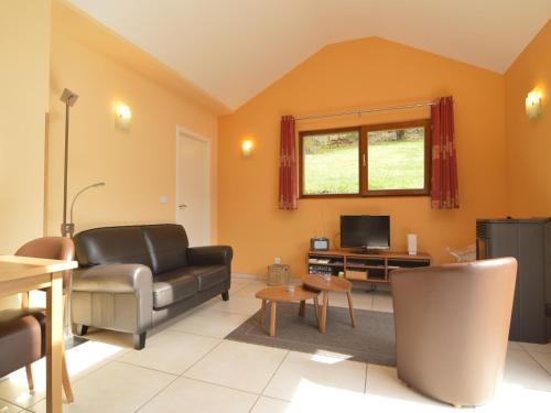 a living room with a couch and a television at Cottage in Aywaille with Garden in Aywaille