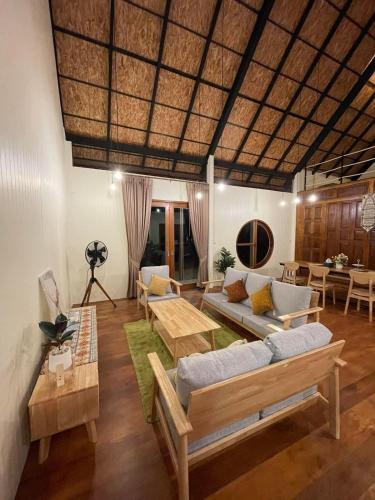 a living room with couches and a table at Peace in Ranong in Ban Cho