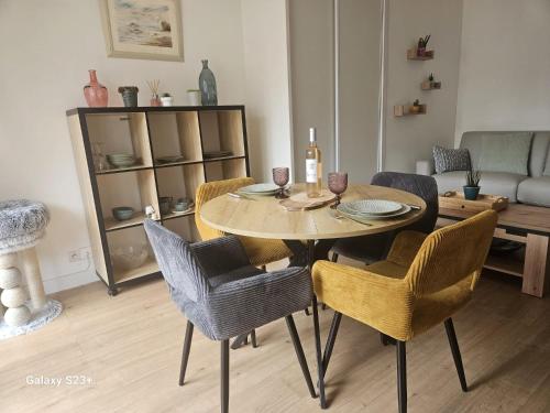 a dining table and chairs in a living room at Studio 2 personnes in Cucq