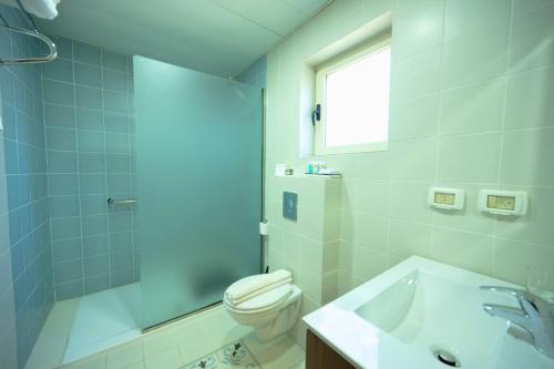 a white bathroom with a toilet and a sink at Lavender Boutique Hotel in Ramallah