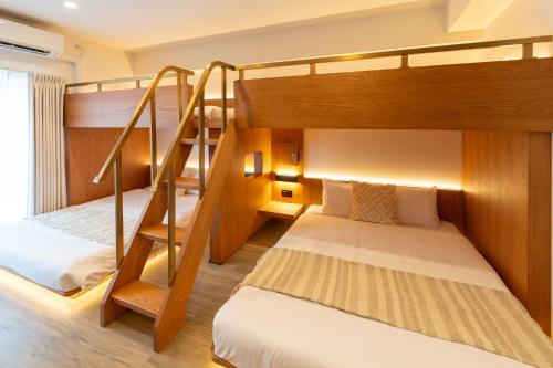 a bedroom with two bunk beds and a staircase at NOVI Dotonbori in Osaka