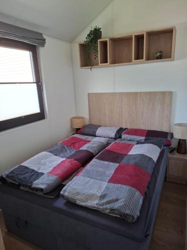 a bed in a room with two pillows on it at Mobilheim Bumblebee im Allgäu in Oberegg