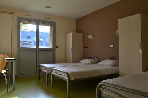 a room with two beds and a window at Centre International de Séjour in Laval