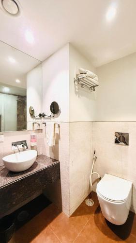 a bathroom with a white toilet and a sink at HOTEL AMORA - Rajnandgaon in Rāj Nāndgaon