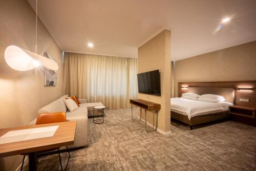 a hotel room with a bed and a couch at Apartmány Kramer in Opava