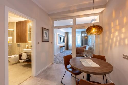 a dining room with a table and a bathroom at Apartmány Kramer in Opava