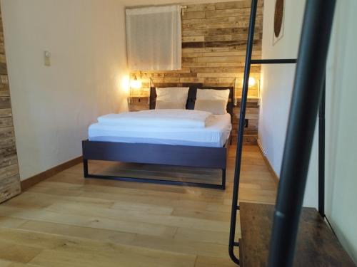 a bedroom with a bed with a wooden wall at Au Grimp'Han in Han-sur-Lesse