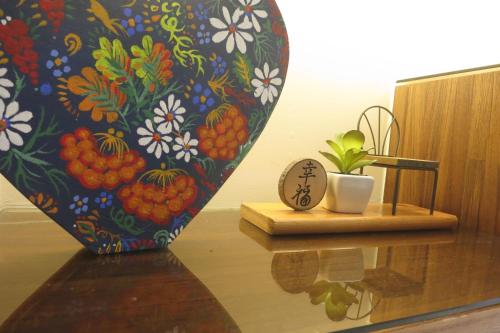 a vase with a plant sitting on a wooden table next to a table at 玉里囍宿民宿 花蓮縣民宿2068號 in Yuli