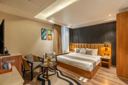 a hotel room with a bed and a chair at Perfectstayz Premium Mahadev Regency in Katra
