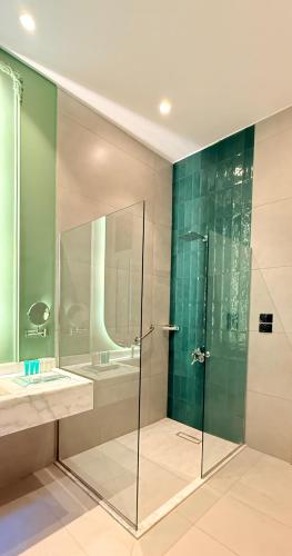 a bathroom with a glass shower and a sink at AJIRA Zamalek Hotel in Cairo