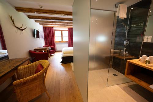 a hotel room with a shower and a bedroom at Hotel Hartenfels in Lech am Arlberg