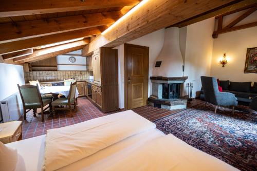 a bedroom with a bed and a living room with a fireplace at Hotel Hartenfels in Lech am Arlberg