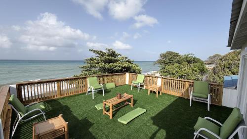 a balcony with chairs and a table and the ocean at YAI Wellness Oasis in Yallahs