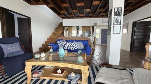 a living room with a blue couch and a table at YAI Wellness Oasis in Yallahs