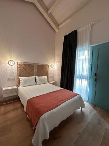 a bedroom with a large bed and a large window at O Legado de Ramira in Villanueva de Arosa