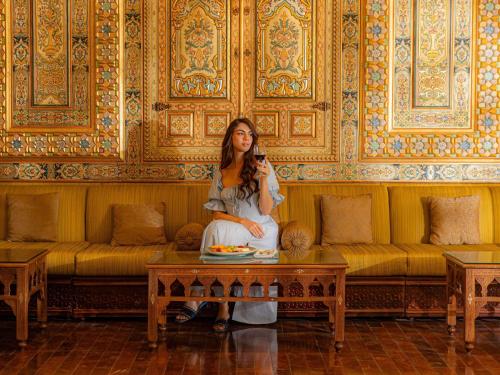a woman sitting on a coffee table in a room at Mövenpick Resort Petra in Wadi Musa