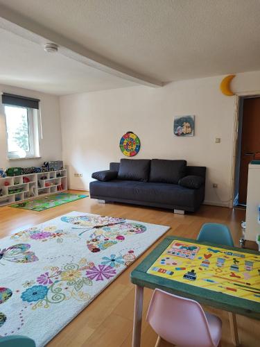 a living room with a couch and a table at Ferienhaus Eden Frankenblick I Rennsteig I Thüringer Wald I Wandern I Naturnah I nahe Skipiste l Spielzimmer I Waschmaschine I kostenlos parken I WLAN I Spülmaschine I Familien-Ferienhaus I Waldwege und Wanderwege in Mengersgereuth-Hämmern