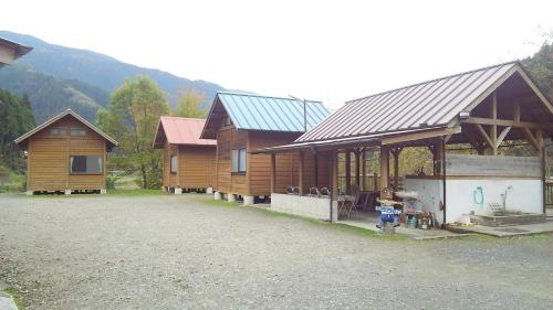 a group of wooden cabins with mountains in the background at Haecho County - Camp - Vacation STAY 42289v in Oshite