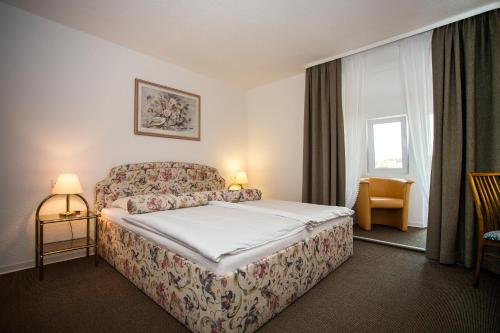 a hotel room with a bed and a chair at Hotel Wagner Am Marktplatz in Bad Wimpfen