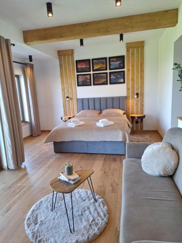 a bedroom with a bed and a couch and a table at Apartament Polana No 24 in Bańska Wyżna