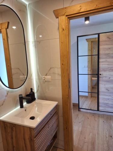 a bathroom with a sink and a mirror at Apartament Polana No 24 in Bańska Wyżna
