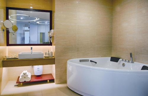 a bathroom with a white tub and a sink at Jie Jie Beach by Jetwing in Wadduwa