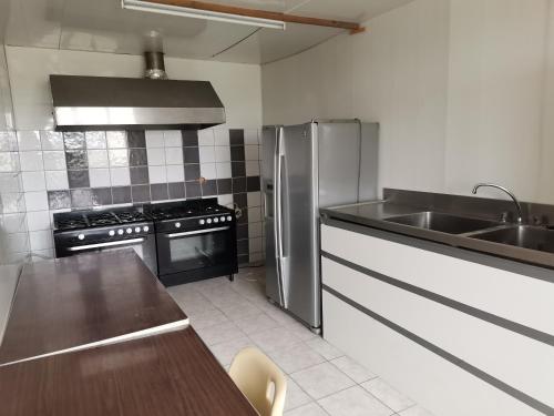 a kitchen with a stainless steel refrigerator and a sink at Sky and Bel Air in Saint-Philbert-de-Bouaine