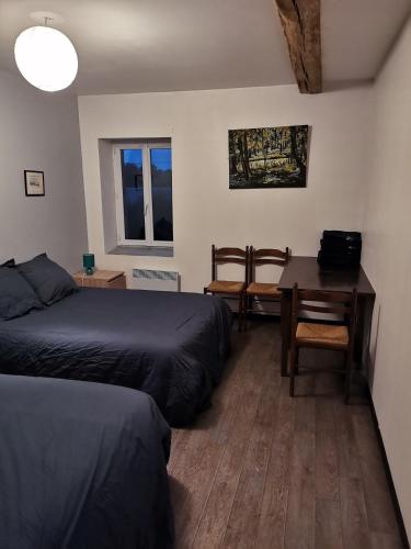 a bedroom with two beds and a desk and a table at Sky and Bel Air in Saint-Philbert-de-Bouaine