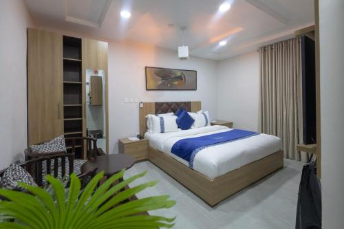 a bedroom with a bed and a chair in a room at Aduke's Residence Abuja in Abuja