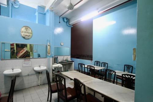een eetkamer met tafels en stoelen en blauwe muren bij Backpacker Cozy Corner Guesthouse in Singapore