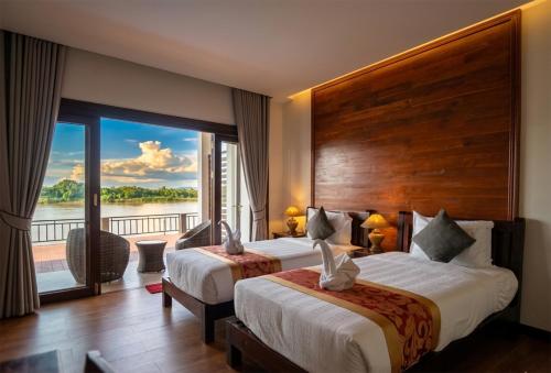 a hotel room with two beds and a balcony at Paradise resort, Don Det river view in Don Det