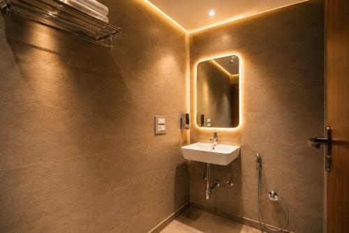 a bathroom with a sink and a mirror at Hotel Bricks, Karol Bagh, New Delhi in New Delhi