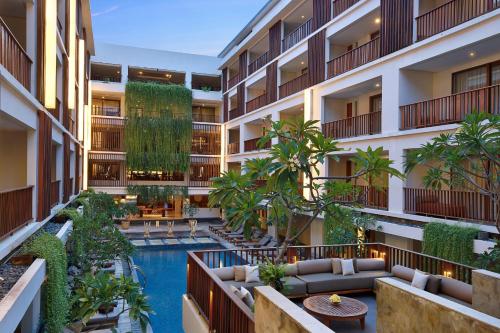 an image of an apartment building with a swimming pool at The Magani Hotel and Spa in Legian