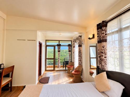 a bedroom with a bed and a large window at Cloud Valley Inn in Cherrapunji