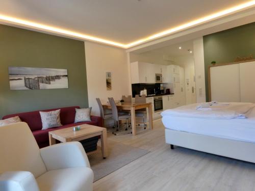 a living room with a bed and a couch and a table at Strand FeWo Rügen Baltic Sea in Binz