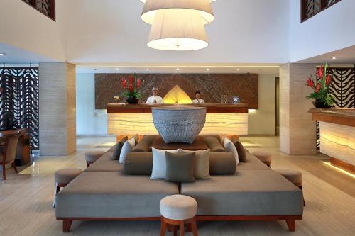a living room with a large couch in a lobby at The Magani Hotel and Spa in Legian