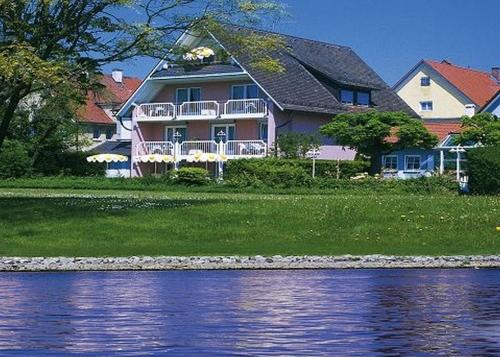 a large house on the shore of a body of water at Hotel Strand-Café mit Gästehaus Charlotte in Langenargen