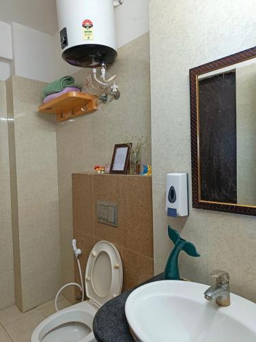 a bathroom with a sink and a toilet and a mirror at 5 Mins from Prem Mandir 1 BHK Apartment in Vrindāvan